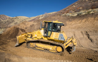 Komatsu D61PXi bulldozer moving soil on a hillside construction site, symbolizing the importance of ROI tracking in construction marketing.